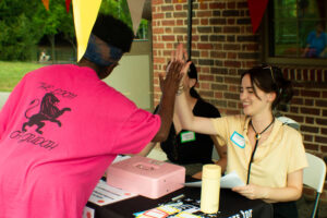 2 PPT members high-fiving and smiling at the check0in table