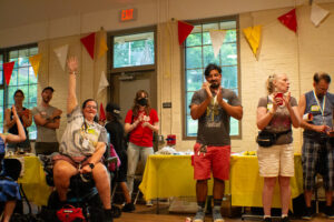 PPT members clapping, smiling, and raising hands at the party