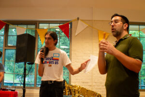Statewide campaign manager Connor Descheemaker speaking into a mic, next to an ASL interpreter