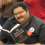 Andrew Hussein, an olive-skinned man reading a book