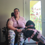 Kelda Gorman, a white woman in a power chair with a service dog
