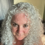 Sue Scanlon, a white woman with long curly white hair